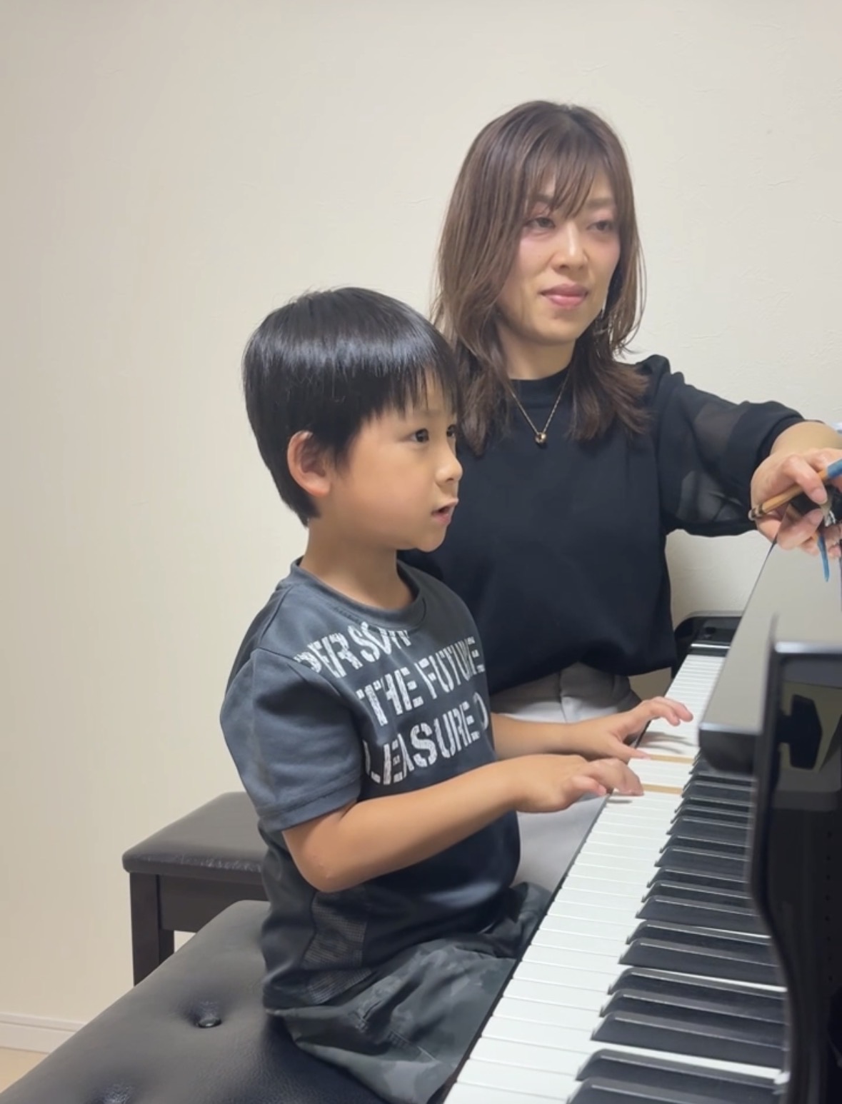 先生が男の子の生徒さんに寄り添って指導している様子