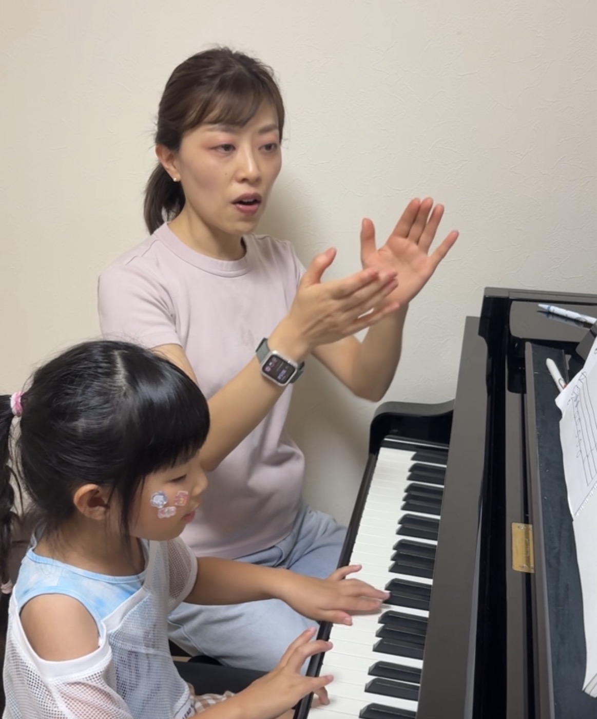 宇都宮市のピアノ教室|子どもがピアノを始めるなら9月がちょうどいい理由 3 レッスンで手のかたちを伝えている講師と、鍵盤に手をおく女の子