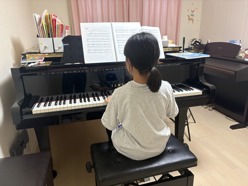 ピアノに向かって練習する生徒さんの後ろ姿